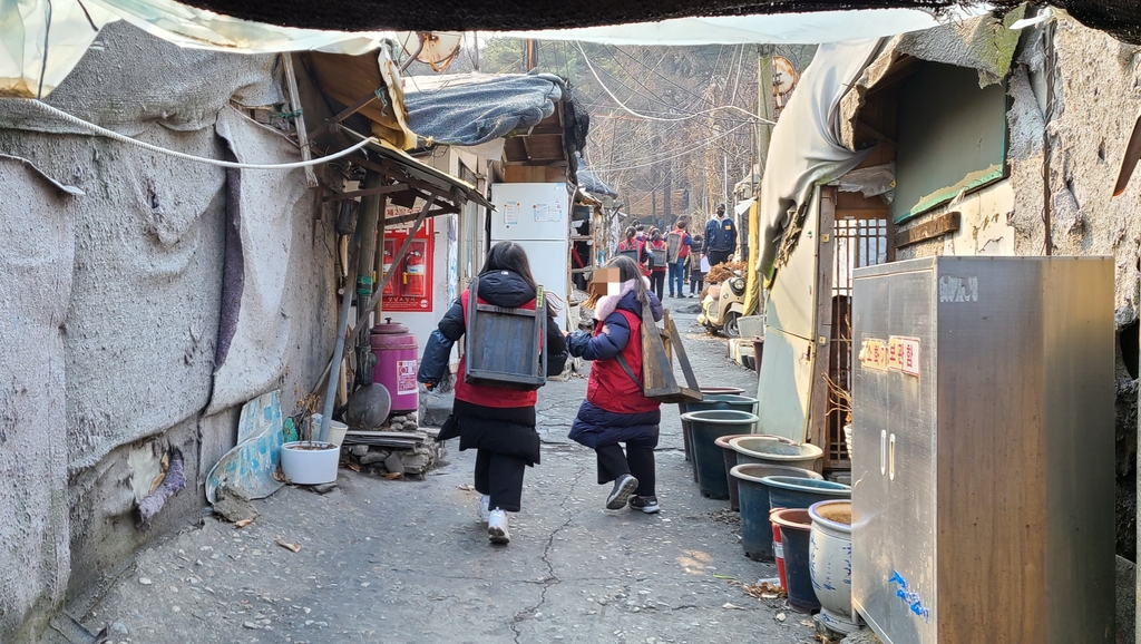 활기차게 골목길을 걷는 연탄 자원봉사자
