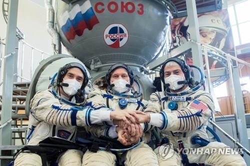 ISS 발사를 앞두고 훈련 중 러시아 우주비행사와 손을 맞잡은 반데 하이(오른쪽)