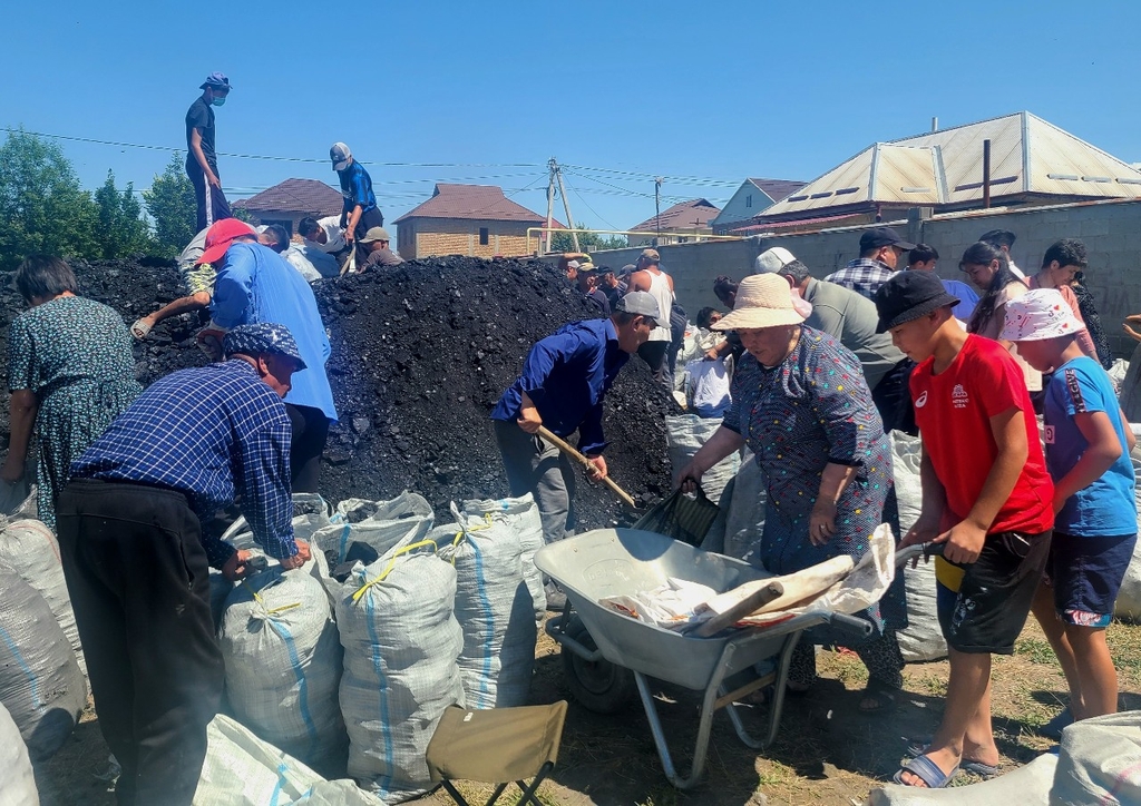 (비슈케크=연합뉴스) 홍규빈 기자 = 7일 키르기스스탄에서 석탄 나눔 작업을 하는 밥상공동체 연탄은행 직원들과 마을 주민들. 2022.6.7rbqls@yna.co.kr