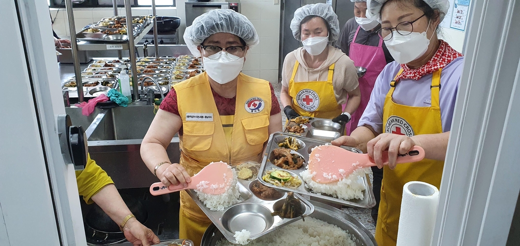 봉사원들과 함께 급식 봉사하는 박말순 실장(왼쪽)