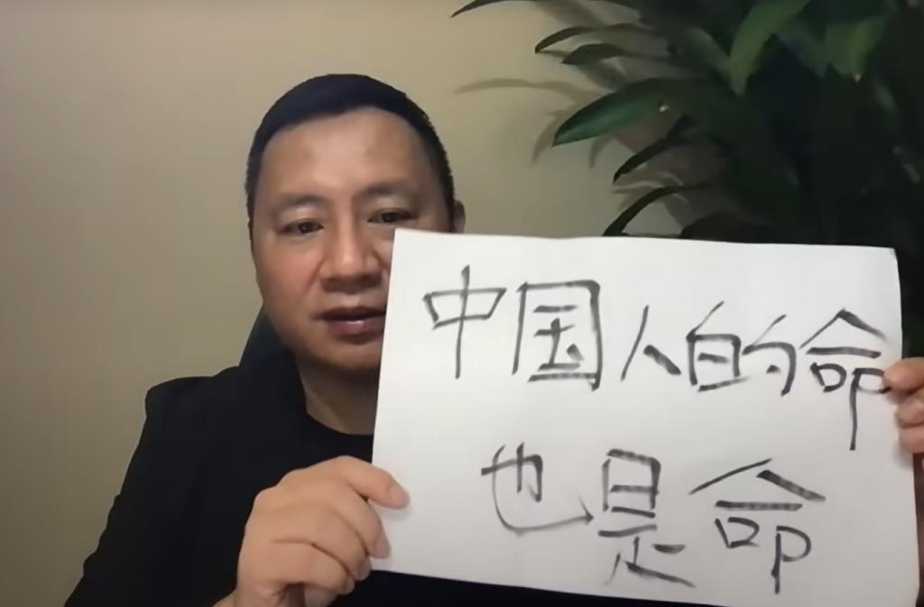 "중국인의 생명도 생명이다"라는 글귀가 쓰여진 종이를 들고 있는 왕단