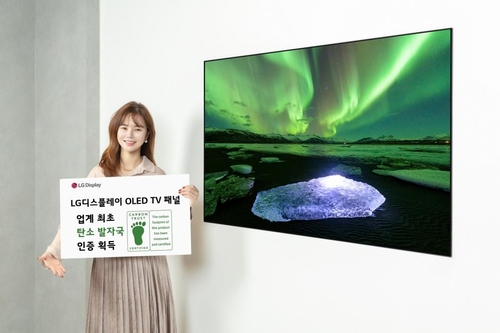 LG디스플레이 OLED TV 패널이 디스플레이 업계 최초로 카본 트러스트 탄소발자국 인증을 획득했다. 사진은 LG디스플레이 모델이 카본 트러스트 인증서와 OLED TV 패널을 소개하는 모습.[LG디스플레이 제공. 재판매 및 DB 금지]