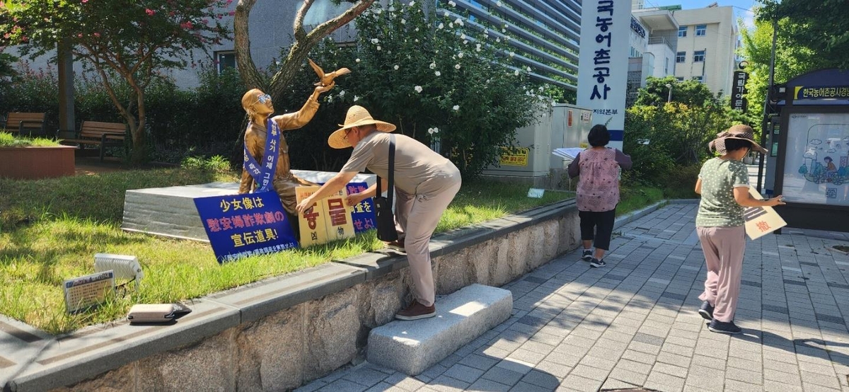 일본군 위안부 피해자 소녀상에 혐오 문구 팻말 설치하는 남성