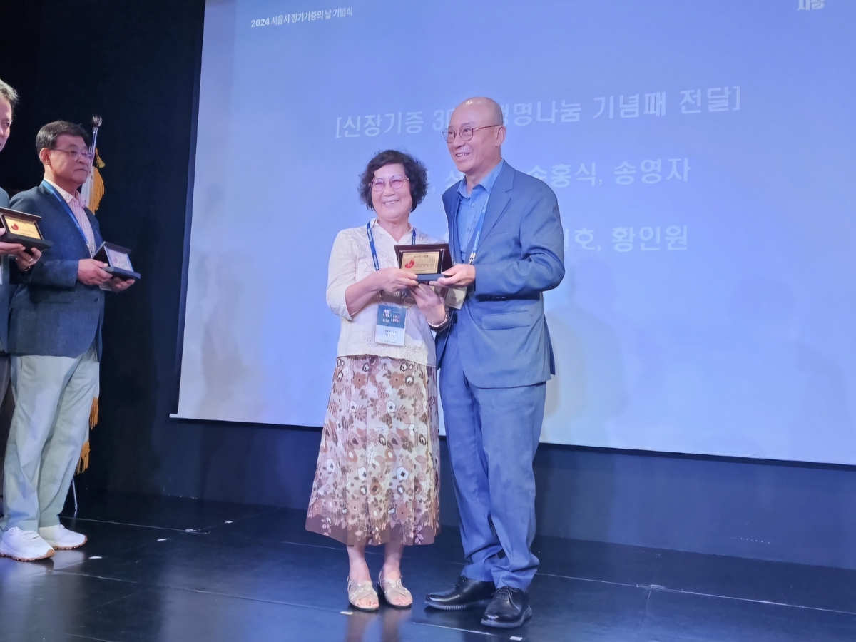 '신장기증 30주년 생명나눔 기념패'를 받는 황인원 씨(왼쪽)