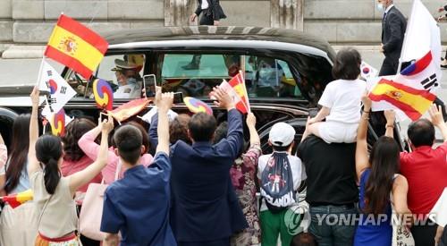 Los surcoreanos residentes en España saludan al presidente surcoreano, Moon Jae-in, mientras pasa, a bordo de un vehículo, el 15 de junio de 2021 (hora local), en Madrid.