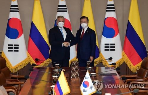 El presidente surcoreano, Moon Jae-in (dcha.), posa para una foto con el presidente colombiano, Iván Duque Márquez (izda.), durante una cumbre celebrada, el 25 de agosto de 2021, en la oficina presidencial, Cheong Wa Dae, en Seúl. 