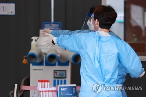 Los trabajadores médicos se preparan para realizar exámenes de coronavirus, el 19 de septiembre de 2021, en una clínica provisional en Seúl.