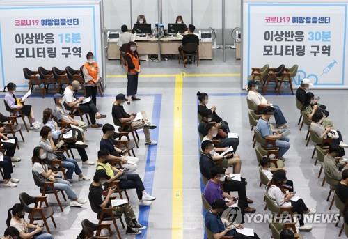 Los ciudadanos esperan sentados para monitorizar posibles efectos secundarios, tras recibir la vacuna contra el nuevo coronavirus, el 24 de septiembre de 2021, en un centro de vacunación, en Seúl. 