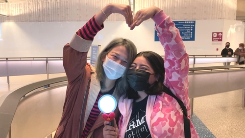 La foto, tomada el 17 de noviembre de 2021 (hora local), muestra a las fanes mexicanas de BTS haciendo una forma de corazón con los brazos y diciendo "borahae", mientras esperan en el Aeropuerto Internacional de Los Ángeles para recibir a la sensación del K-pop BTS.