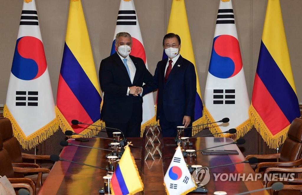 La foto de archivo muestra al presidente surcoreano, Moon Jae-in (dcha.), posando para una foto con el presidente colombiano, Iván Duque Márquez (izda.), durante una cumbre celebrada, el 25 de agosto de 2021, en la oficina presidencial, Cheong Wa Dae, en Seúl. 