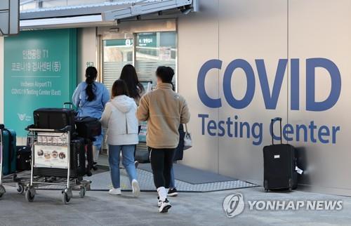 Los viajeros entrantes, procedentes del extranjero, se dirigen a un centro de pruebas del COVID-19, en el Aeropuerto Internacional de Incheon, al oeste de Seúl, el 12 de enero de 2022, tras su llegada a Corea del Sur.