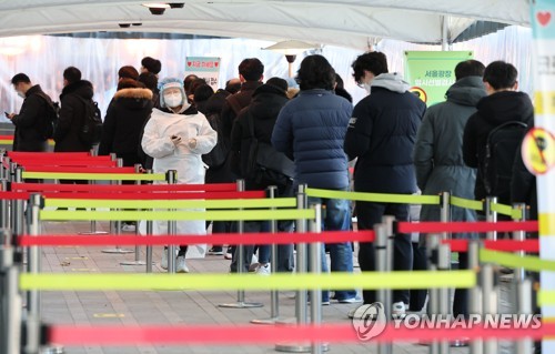La foto, tomada el 18 de enero de 2022, muestra a las personas esperando en fila para someterse a las pruebas del nuevo coronavirus, en una clínica provisional, frente al Ayuntamiento de Seúl, en el centro de la capital surcoreana.