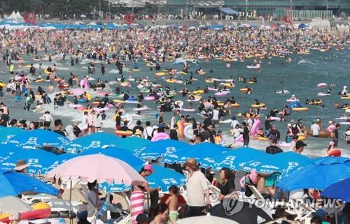 Una playa en la ciudad porteña meridional de Busan, el 14 de agosto de 2022, luce abarrotada de personas.