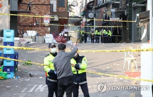 Un policía bloquea la entrada a un callejón en el barrio de Itaewon, en Seúl, el 30 de octubre de 2022, donde ocurrió una estampida mortal durante las festividades por el Halloween, la noche anterior, que dejó un saldo de 153 muertos y 82 heridos.