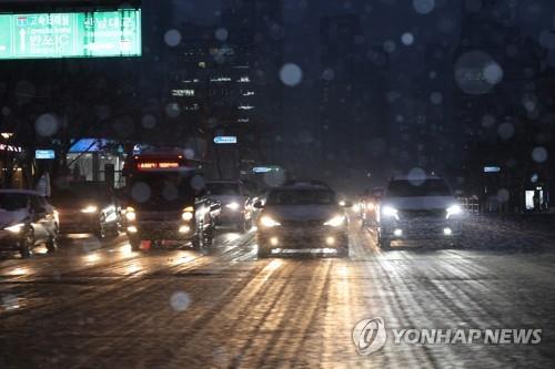 La foto, tomada el 21 de diciembre de 2022, muestra unos vehículos avanzando lentamente en una autopista en Seúl.