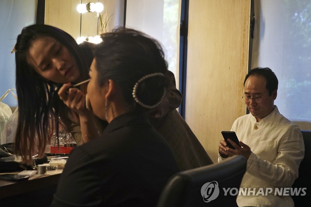 In this Associated Press photo, a makeup artist applies makeup for North Korean soprano singer Kim Song-mi (C) backstage next to South Korean violinist Won Hyung-joon before their performance at the Shanghai Oriental Arts Center in Shanghai on May 12, 2019. (Yonhap)