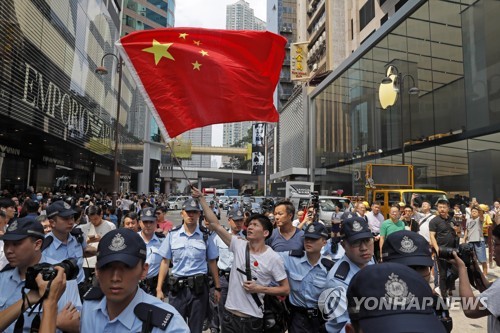 18일 홍콩 쇼핑몰에서 경찰의 보호를 받으며 중국 국기를 흔드는 중국 지지자