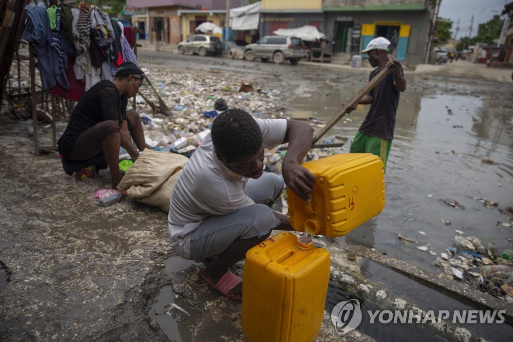 아이티 수도 포르토플랭스 시민들이 물을 담고 있는 모습. [AP 연합뉴스 자료사진. 재판매 및 DB 금지 ]