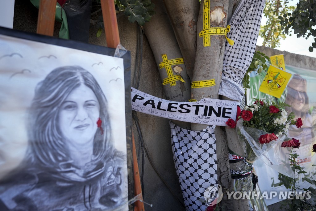 알자지라 소속 시린 아부 아클레 기자가 총격을 받고 사망한 장소에 놓인 꽃다발과 초상화.