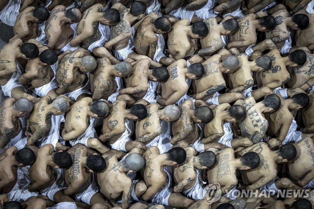 교도소 이감 기다리며 빽빽이 포개 앉은 엘살바도르 갱단원