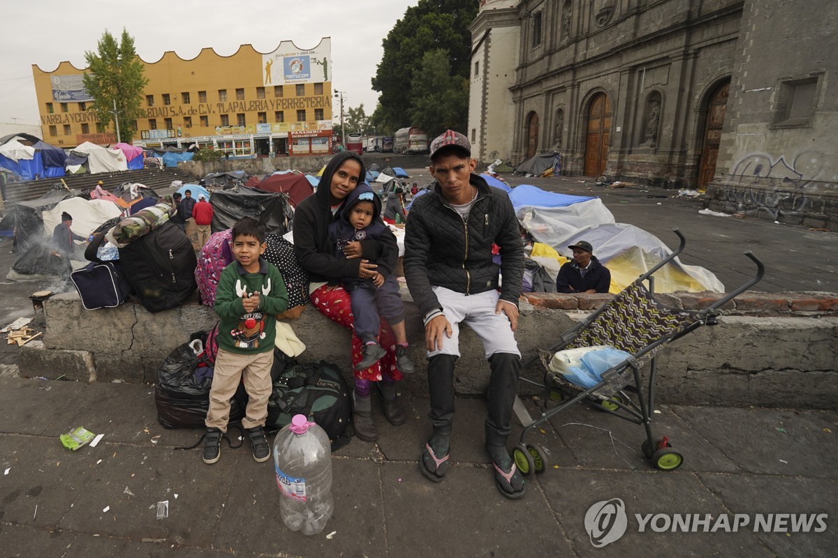 멕시코시티 교회 밖에 앉아 있는 베네수엘라 가족