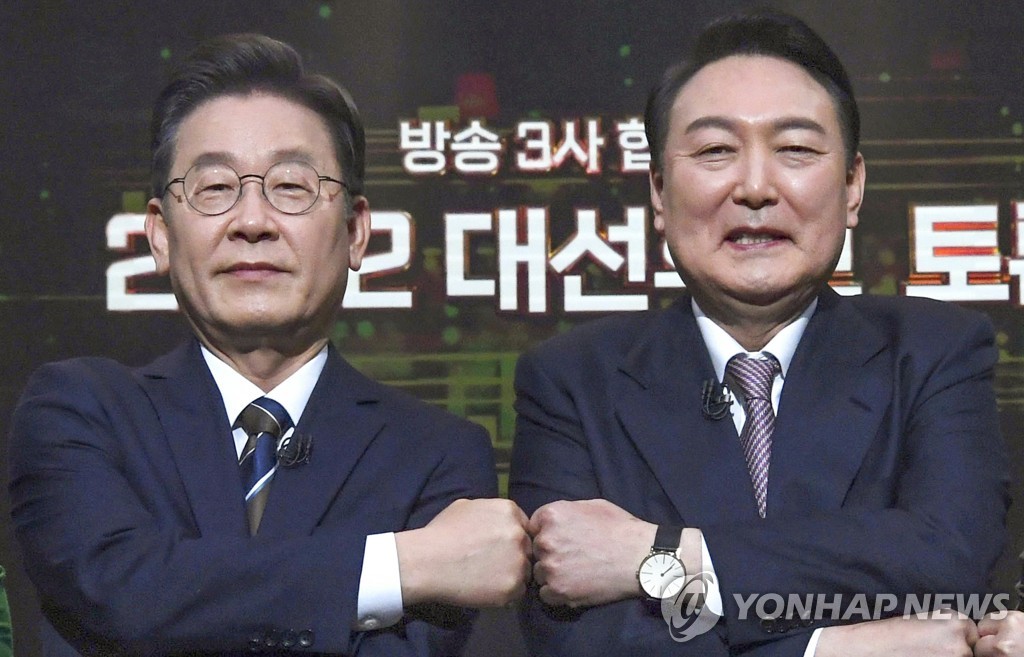 Lee Jae-myung (L), the presidential nominee of the ruling Democratic Party, poses with Yoon Suk-yeol, the nominee of the main opposition People Power Party, during a TV debate held at a KBS TV studio in Seoul on Feb. 3, 2022. (Pool photo) (Yonhap)