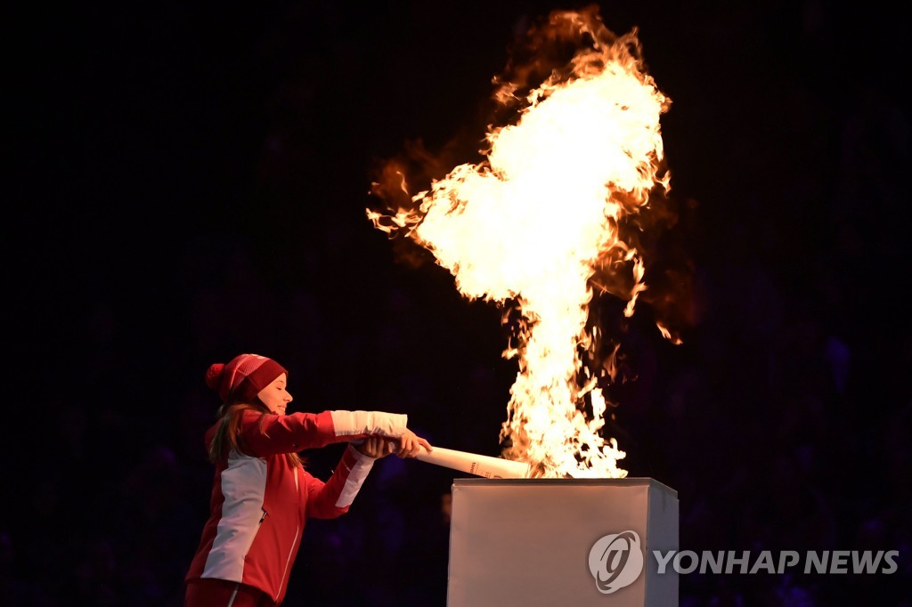 In this AFP photo, Swiss athlete Gina Zehnder lights the Olympic cauldron with the Olympic torch during the opening ceremony of the 2020 Winter Youth Olympics at Lausanne Vaudoise Arena in Lausanne, Switzerland, on Jan. 9, 2020. (Yonhap)