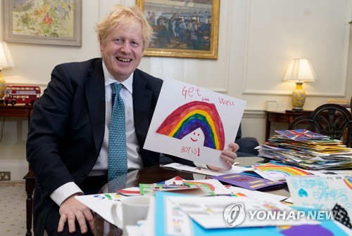 지난달 28일 보리스 존슨 영국 총리가 자신이 코로나19로 입원 중일 때 어린이들이 보낸 회복 기원 편지들을 보여주며 웃고 있다. [AFP·영국총리실·앤드루 파슨스=연합뉴스 자료사진]