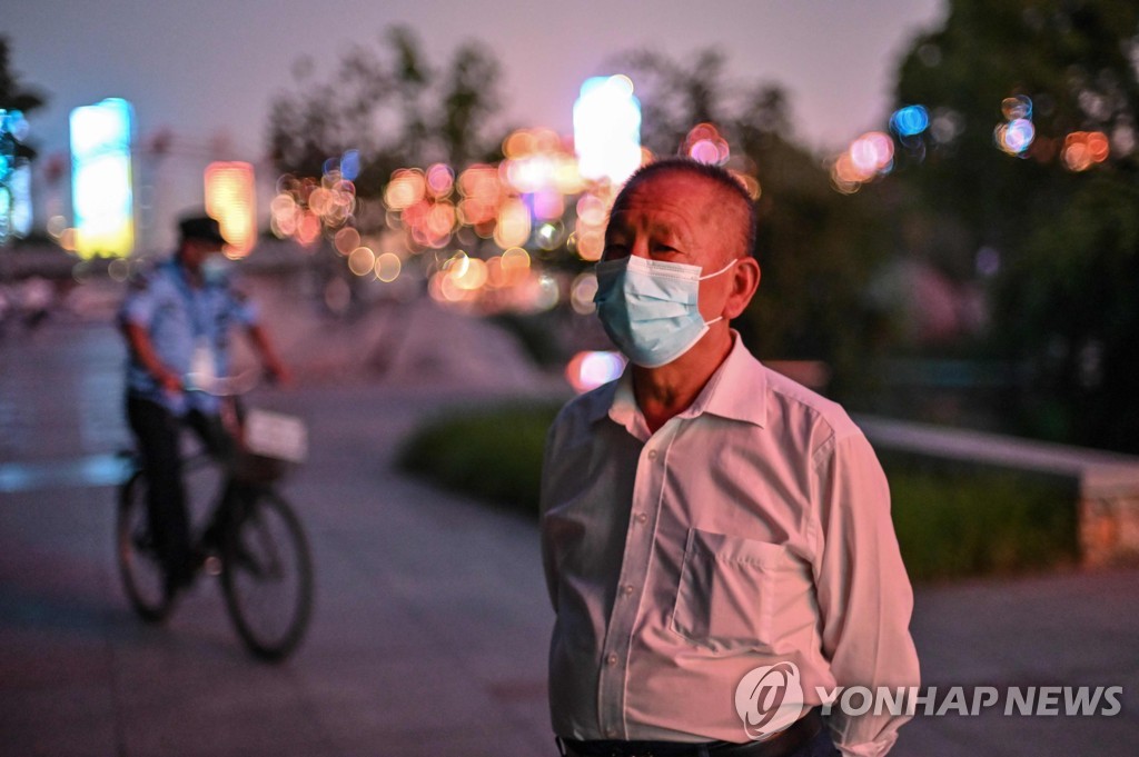 중국 우한의 공원에서 한 남성이 마스크를 쓰고 있다. [AFP=연합뉴스 자료사진]