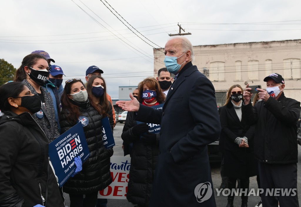 This AFP photo shows Democratic presidential candidate Joe Biden (third from R) speaking to a group of people while visiting his hometown of Scranton, Pennsylvania, on Nov. 3, 2020. (PHOTO NOT FOR SALE) (Yonhap)