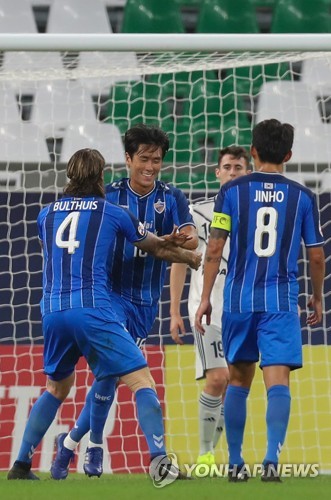 In this AFP photo, Won Du-jae of Ulsan Hyundai FC (C) is congratulated by teammate Dave Bulthuis (L) after scoring a goal against Melbourne Victory during their round of 16 match at the Asian Football Confederation Champions League at Education City Stadium in Al-Rayyan, Qatar, on Dec. 6, 2020. (Yonhap)