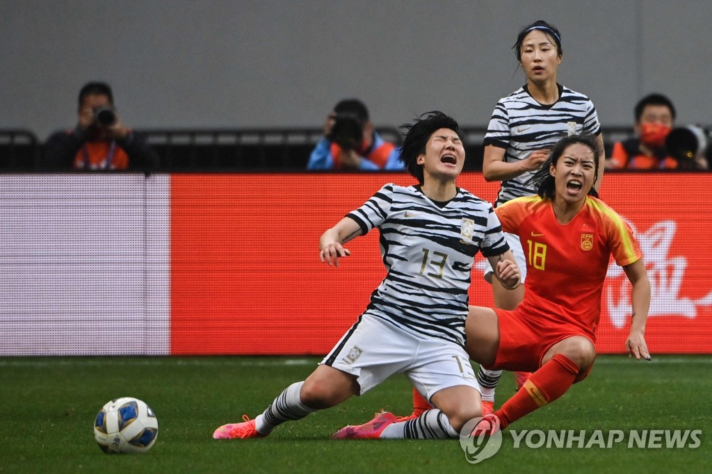 In this AFP photo, Lee Geum-min of South Korea (L) collides with Tang Jiali of China during the teams' Olympic women's football qualifying match at Suzhou Olympic Sports Centre in Suzhou, China, on April 13, 2021, in this photo provided by the Korea Football Association. (Yonhap)