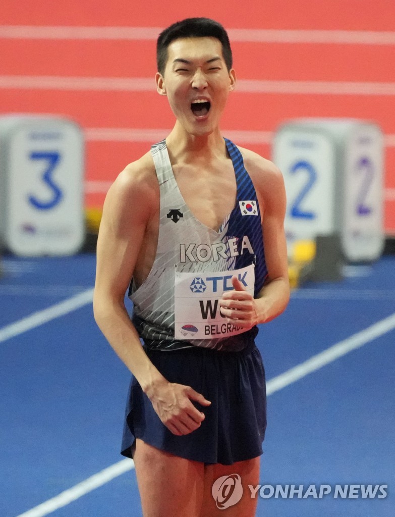 In this AFP photo, Woo Sang-hyeok of South Korea (C) celebrates after winning gold in the men's high jump at the World Athletics Indoor Championships at Stark Arena in Belgrade on March 20, 2022. (Yonhap)