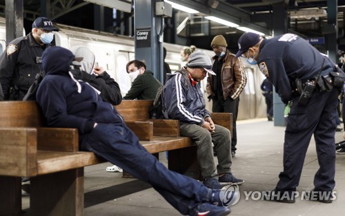 뉴욕 지하철역에서 노숙자에게 질문하는 경찰