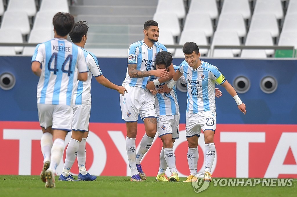 In this EPA photo, Yoon Bitgaram of Ulsan Hyundai FC (2nd from R) is mobbed by teammates Bjorn Johnsen (L) and Kim Tae-hwan after scoring a goal against FC Tokyo during their Group F match at the Asian Football Confederation Champions League at Education City Stadium in Al Rayyan, Qatar, on Nov. 30, 2020. (Yonhap)