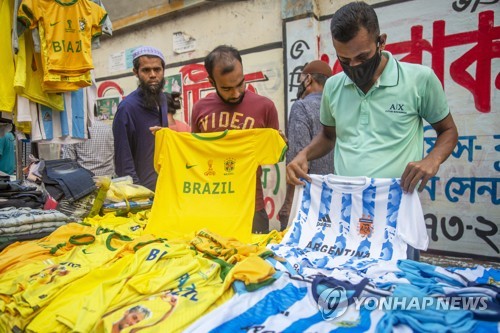 방글라데시 다카의 한 노점상에서 월드컵 축구 유니폼을 고르는 손님들