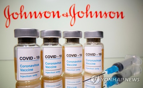 미국 제약사 '존슨앤드존슨'의 로고 앞에 신종 코로나바이러스 감염증(코로나19) 백신이라고 쓰여있는 병이 놓여있는 일러스터[로이터=연합뉴스 자료사진]