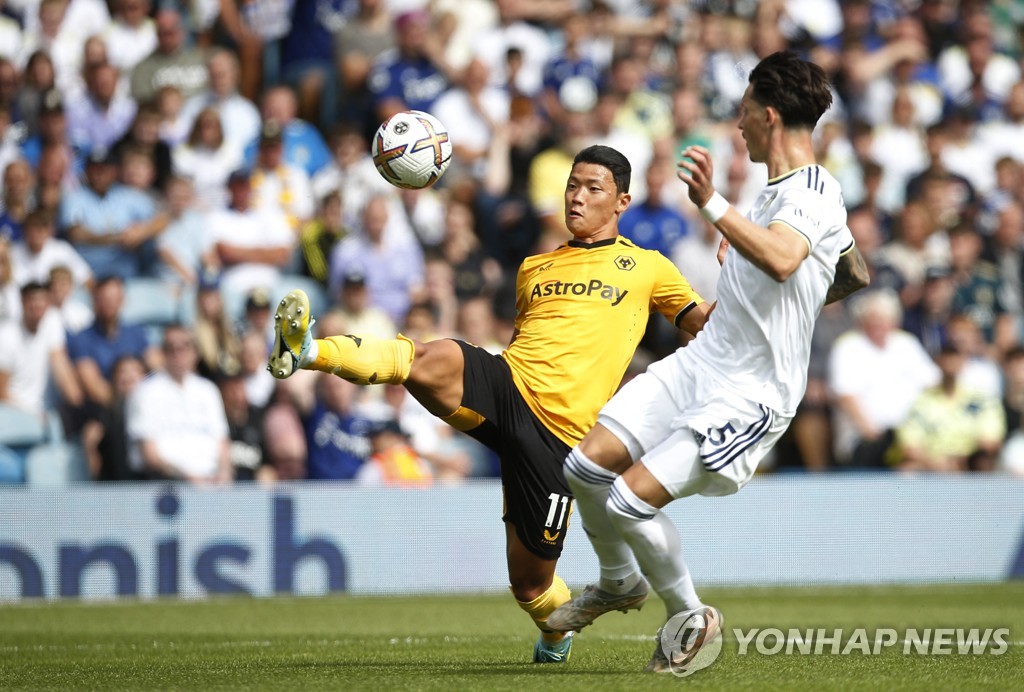 In this Reuters photo, Hwang Hee-chan of Wolverhampton Wanderers (L) is in action against Robin Koch of Leeds United during the clubs' Premier League match at Elland Road in Leeds, England, on Aug. 6, 2022. (Yonhap)
