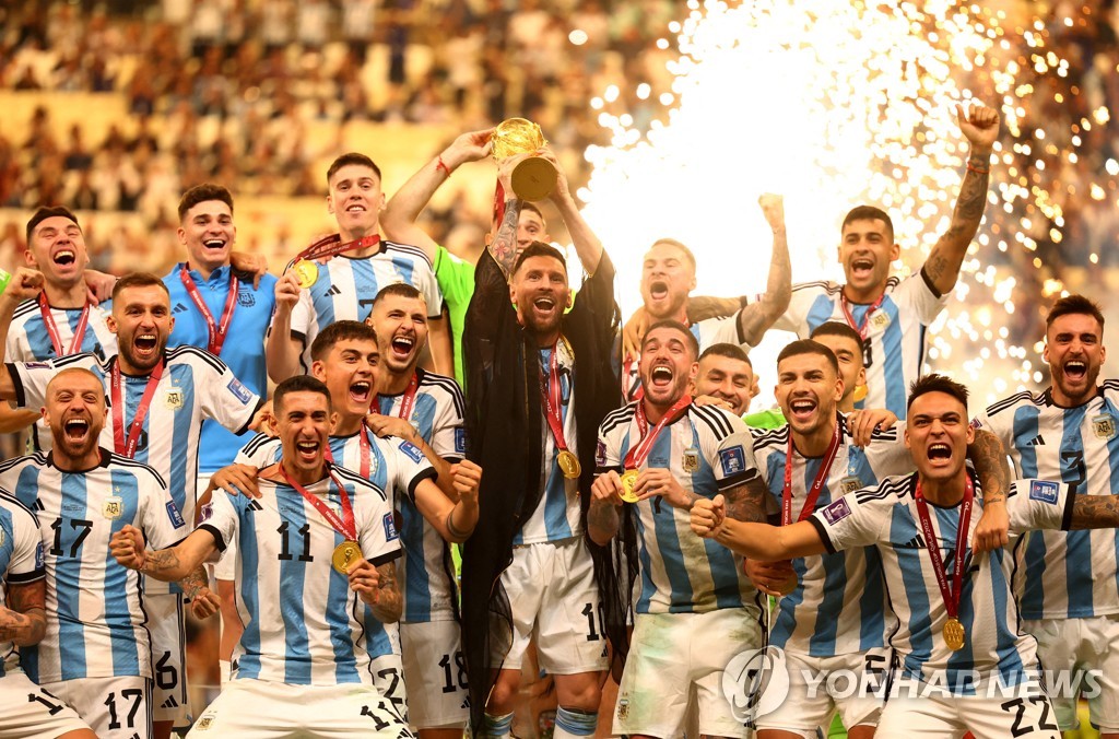 아르헨티나가 36년 만에 월드컵 우승을 차지한 가운데 주장 리오넬 메시가 트로피를 들어 올리자 선수들이 환호하고 있다.