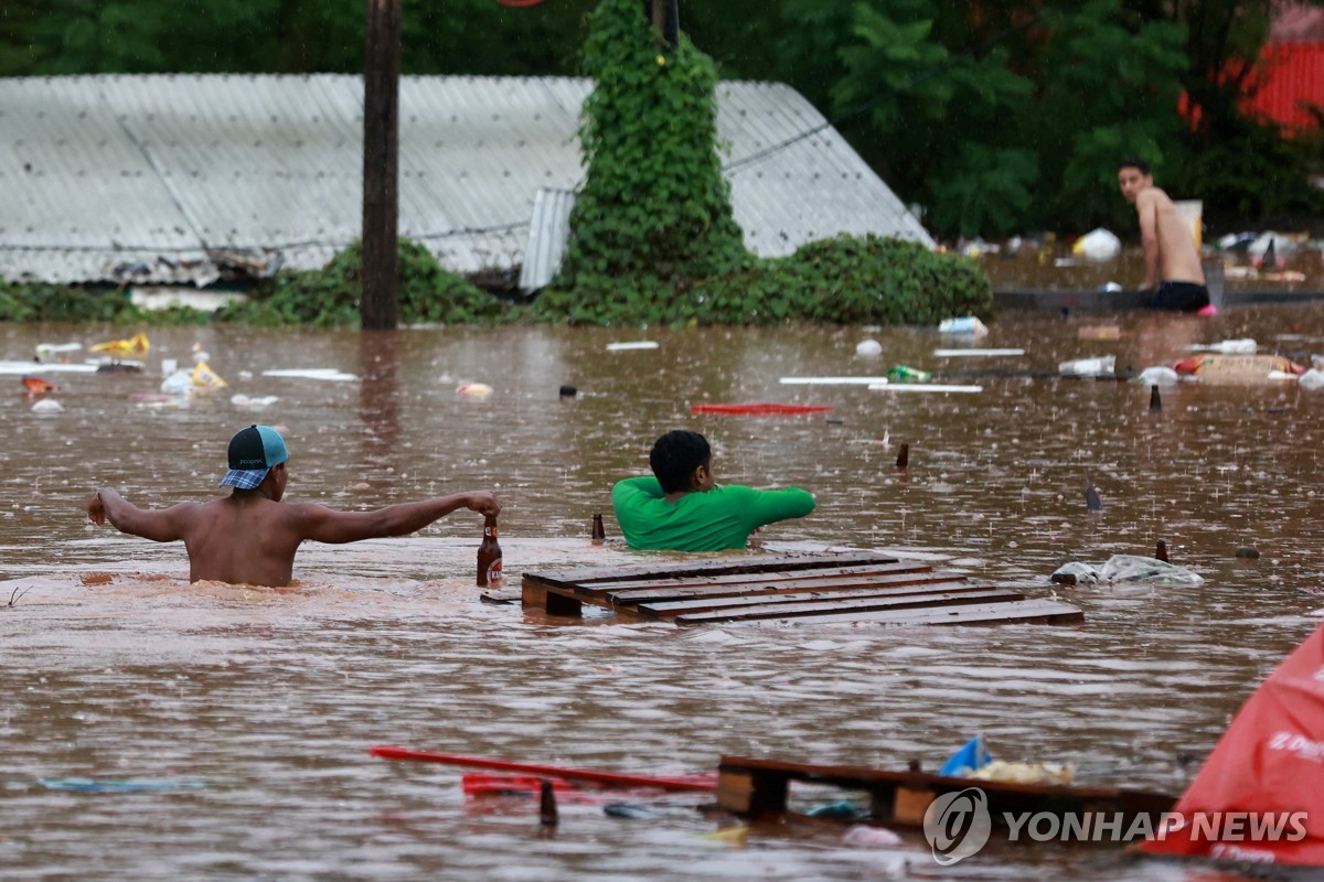 침수된 도로 지나가는 브라질 주민들