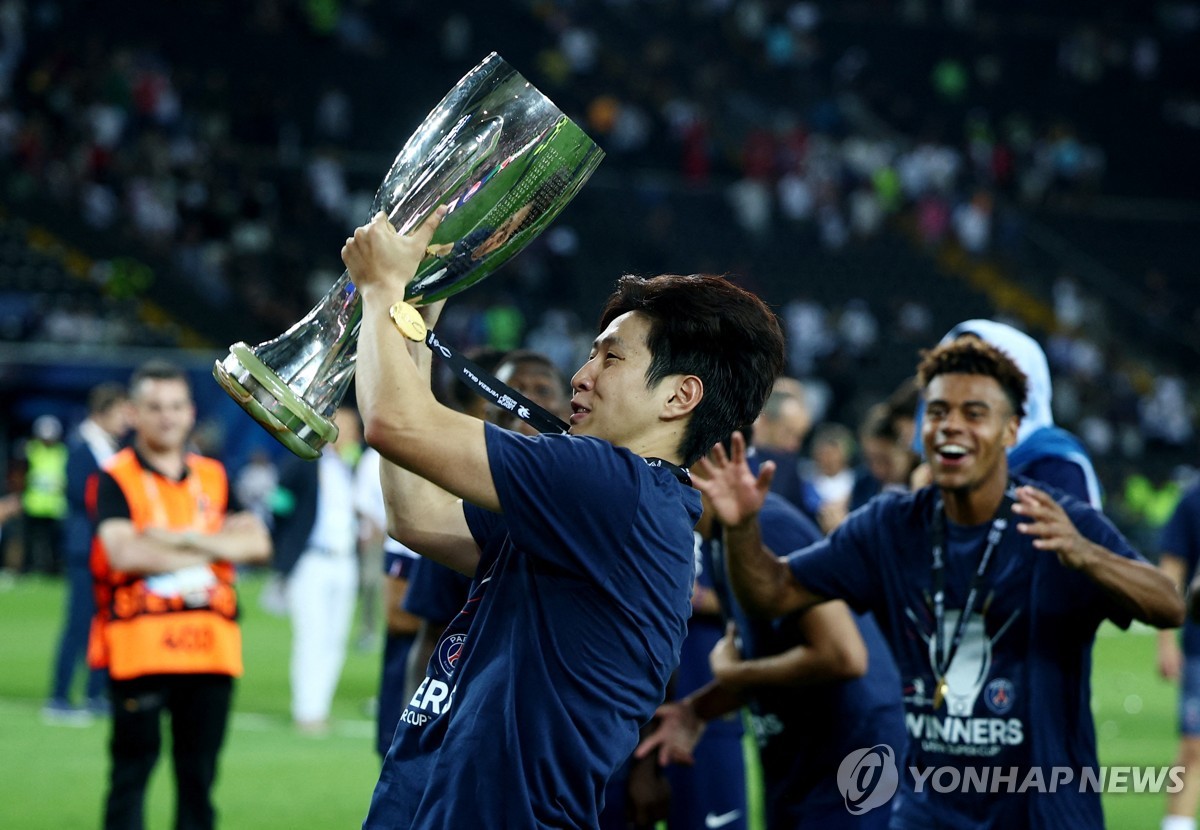 메달을 목에 걸고 팬 앞에서 트로피를 들어 올리는 이강인