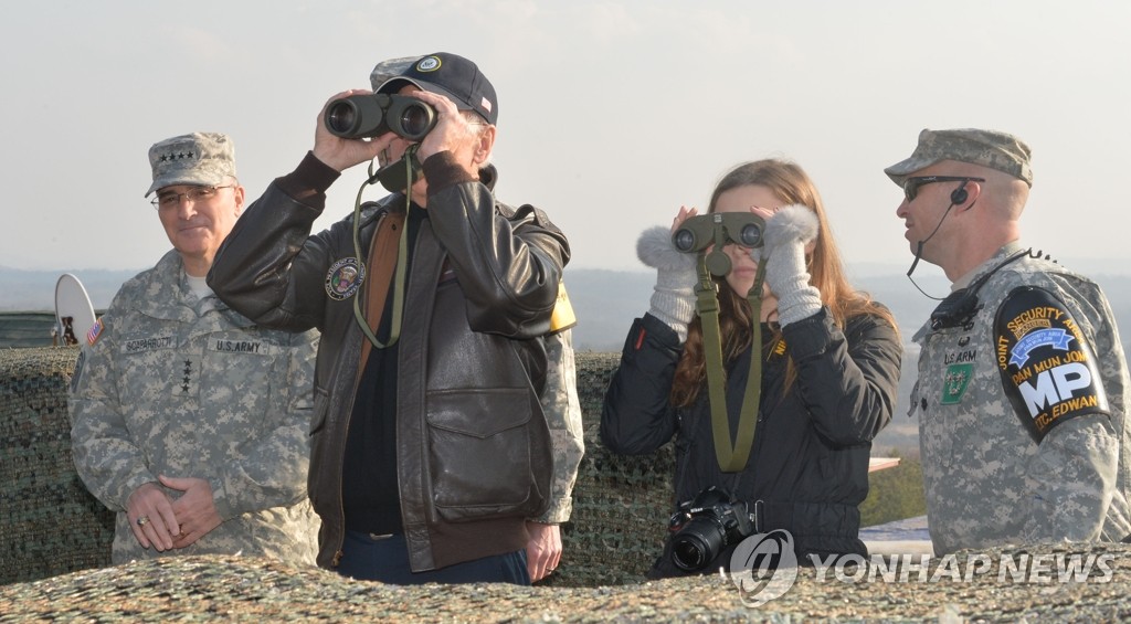 In this file photo, taken Dec. 8, 2013, then visiting U.S. Vice President Joe Biden and his granddaughter, Finnegan, are seen looking at North Korea through binoculars during a visit to a guard post near the Demilitarized Zone (DMZ) that bisects the two Koreas. (Pool Photo) (Yonhap)