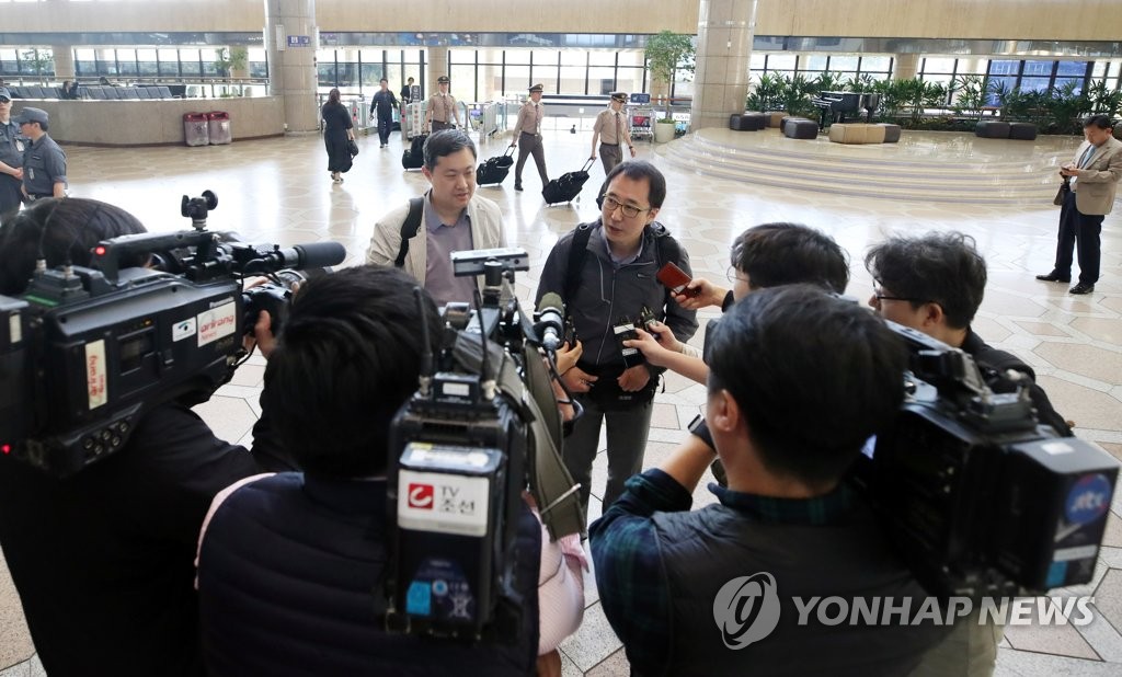 出発にあたり空港で質問に答える韓国の記者＝２１日、ソウル（聯合ニュース）