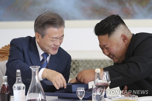 In the photo, taken Sept. 19, 2018, South Korean President Moon Jae-in (L) delights North Korean leader Kim Jong-un during their bilateral summit in Pyongyang by presenting medallions commemorating their first bilateral summit held in April and Kim's first meeting with U.S. President Donald Trump held in Singapore in June. (Yonhap)