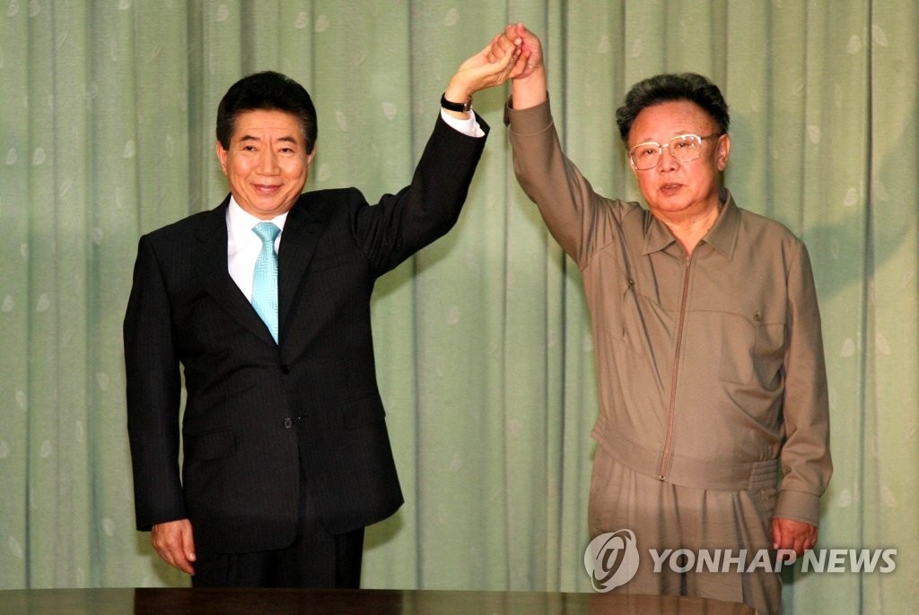 ２００７年１０月４日、１０・４宣言に署名後、取り合った手を高く掲げる盧武鉉大統領（左）と金正日総書記（資料写真、大統領府写真記者団）＝（聯合ニュース）