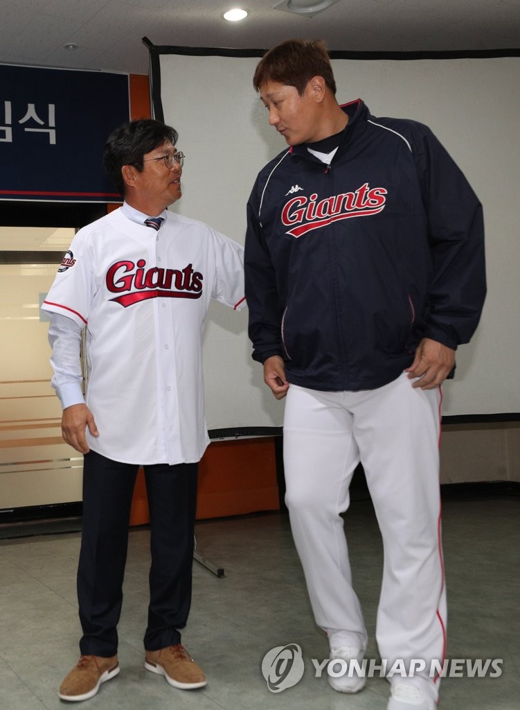 In this file photo from Nov. 26, 2018, Yang Sang-moon (L), new manager of the Lotte Giants, and Lee Dae-ho, the team's designated hitter, greet each other during Yang's inauguration at Sajik Stadium in Busan, 450 kilometers southeast of Seoul. (Yonhap)