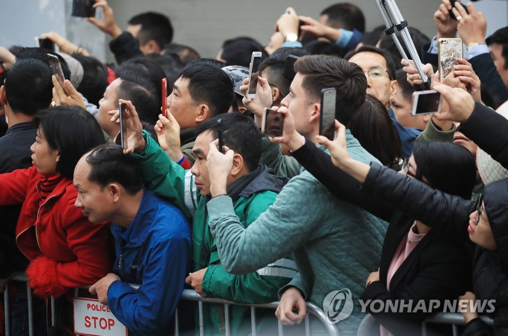 People in Hanoi try to catch a glimpse of North Korean leader Kim Jong-un in front of his hotel on Feb. 26, 2019. (Yonhap)