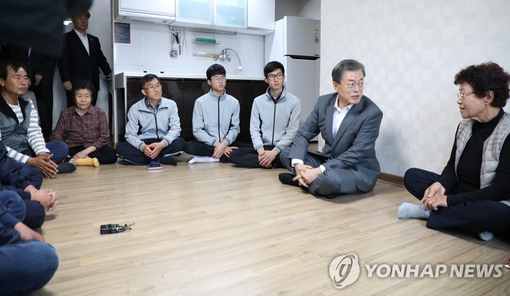 President Moon Jae-in (2nd from R) talks with residents who were displaced by a wildfire in Gangwon Province at a Sokcho shelter on April 26, 2019. (Yonhap)