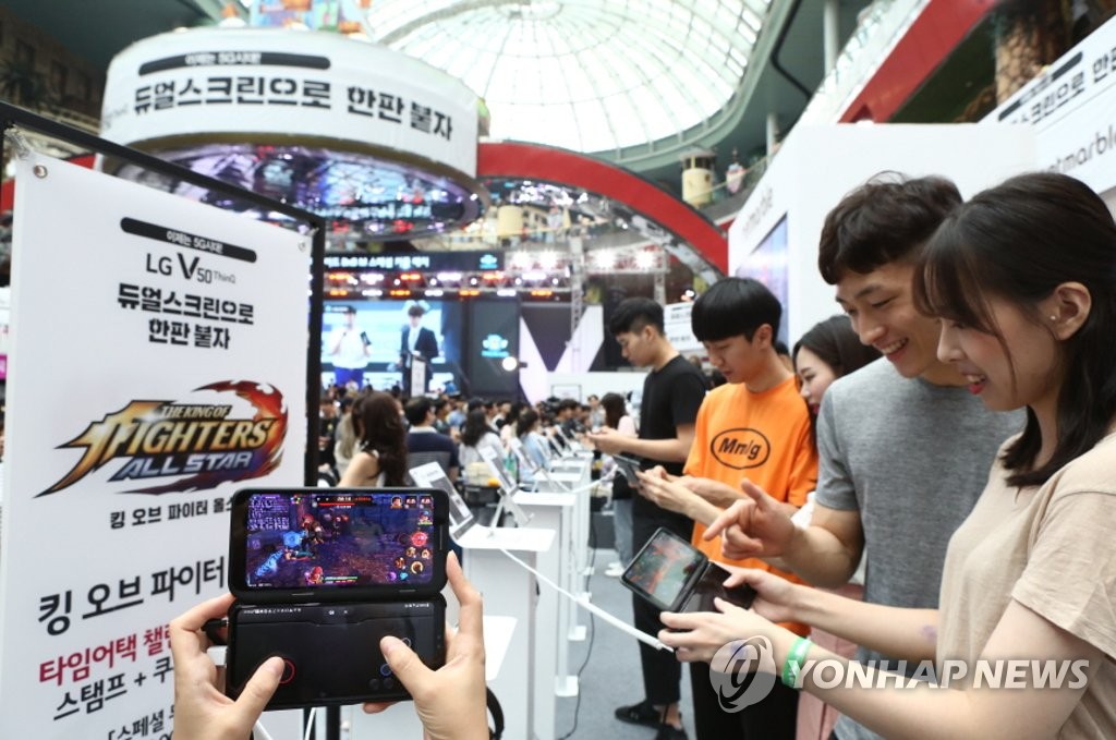 Visitors to LG Electronics Inc.'s mobile game festival held at Lotte World's ice link in Seoul enjoy game on V50 ThinQ smartphone on July 21, 2019, in this photo provided by the company. (PHOTO NOT FOR SALE) (Yonhap)
