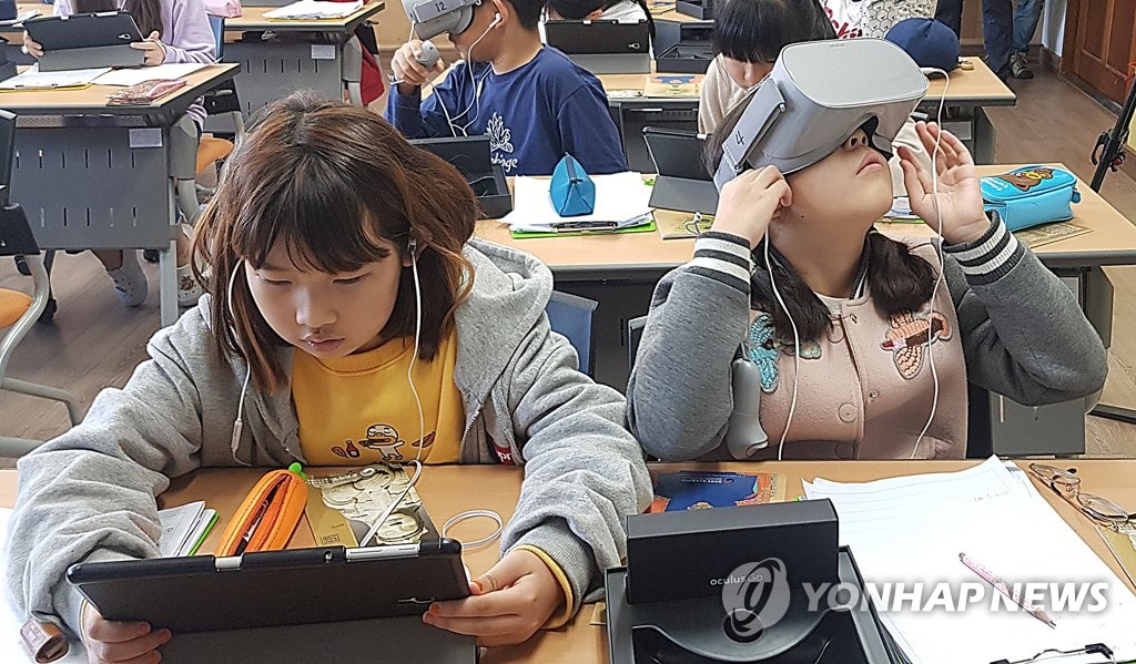 This file photo from Nov. 4, 2019, show students at an elementary school in Uijeongbu, north of Seoul, testing virtual reality gadgets in class. This photo is not directly associated with the news story. (Yonhap)